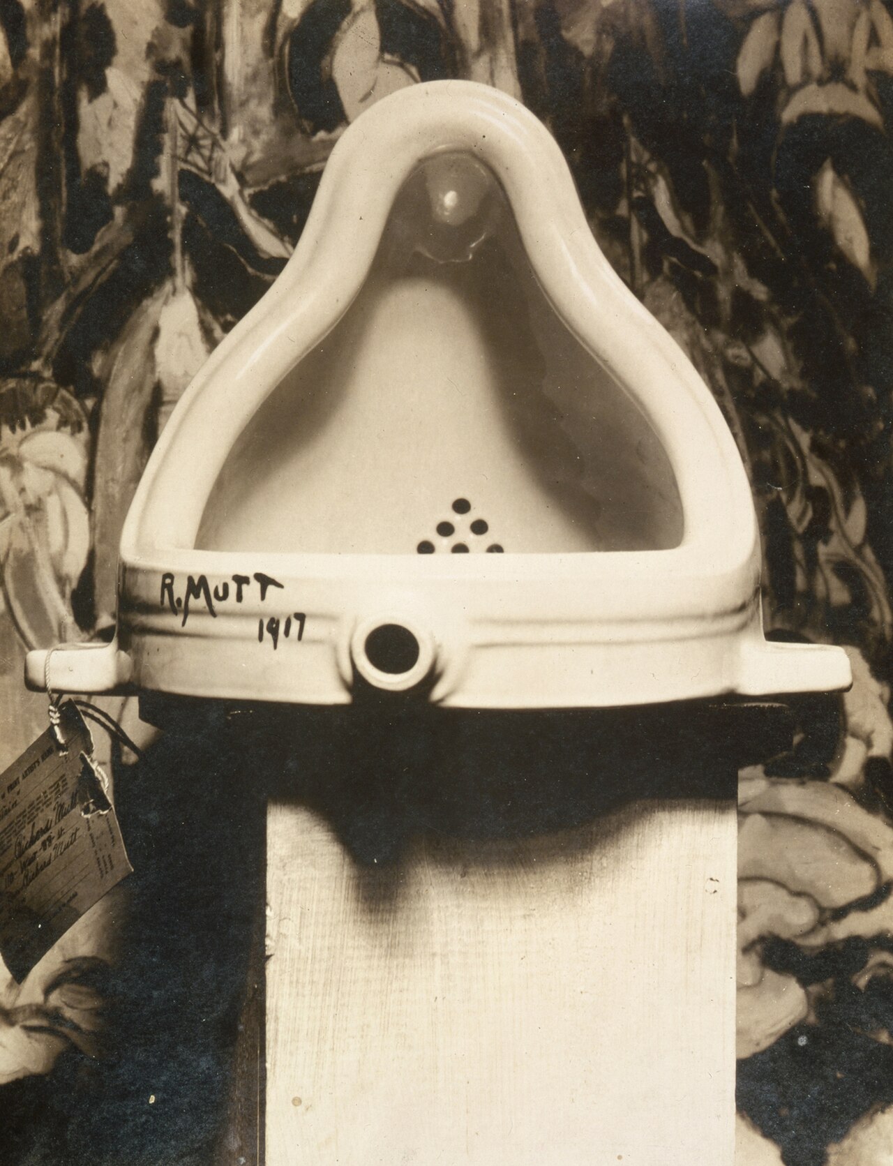 Photographie en noir et blanc de Fountain de Marcel Duchamp : un urinoir en porcelaine posé à l'envers sur un socle, signé « R. Mutt 1917 ».